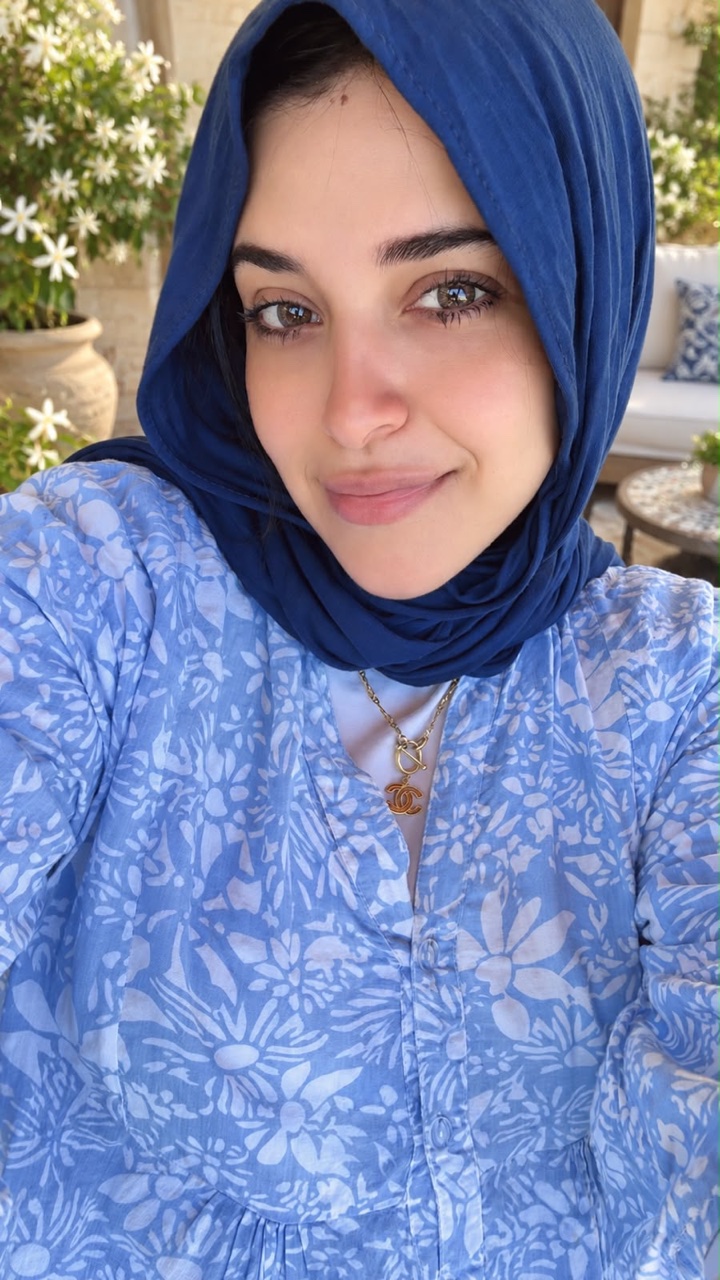 Dr. Soso outdoors in a blue hijab and floral blouse